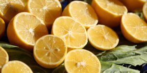 Bright lemon halves arranged on fresh green leaves, ideal for various dishes and drinks