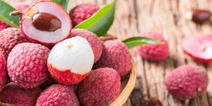 fresh organic lychee fruit on bamboo basket and old wood background