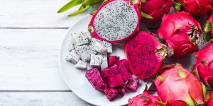 fresh white and pink red purple dragon fruit tropical in the asian thailand healthy fruit concept, dragon fruit slice and cut half on white plate with pitahaya background